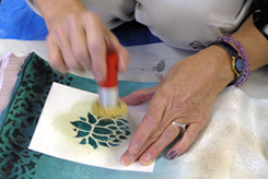 Betsy demonstrating the use of a wax stencil.